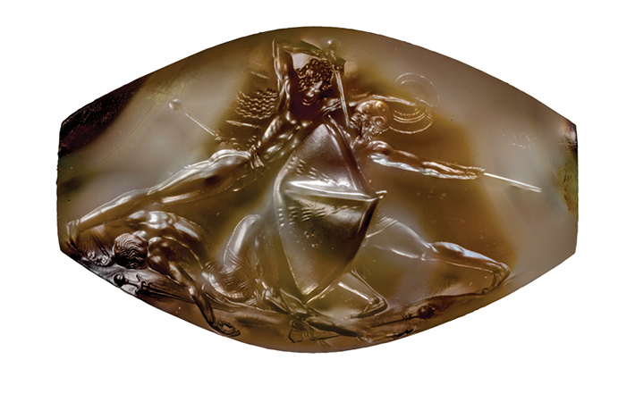 The Pylos Combat Agate is one of 50 decorated seal stones to have been found in the Griffin Warrior’s tomb. It measures only 1.4 inches wide and depicts a leaping warrior stabbing an armored enemy in the neck. Another foe lies dead at his feet.