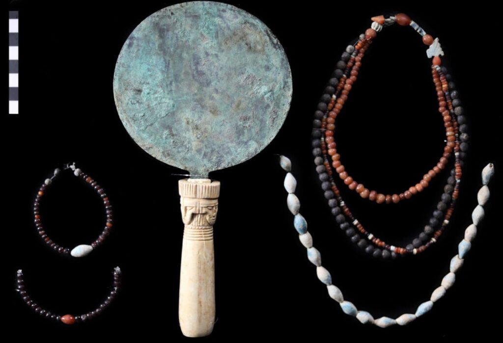 Copper mirror and jewelry recovered from a tomb at the Asasif necropolis in Thebes