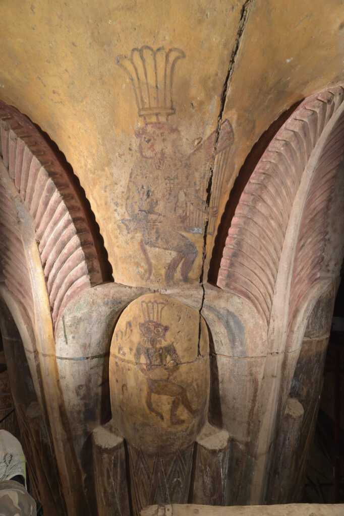 Painting on an interior capital of the dwarf deity Bes playing a harp and a drum