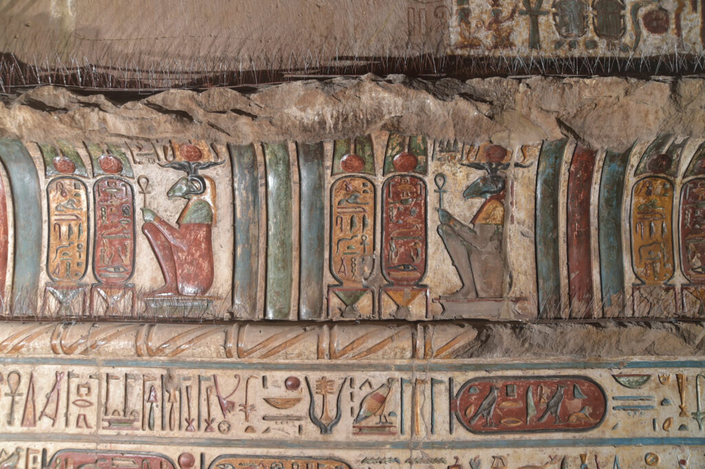 Painted reliefs of the ram-headed creator god Khnum and oval cartouches with the name of Ptolemy VI