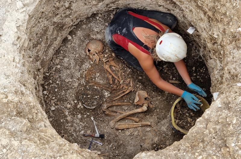 An archaeologist excavates a Late Iron Age Durotriges burial at Winterborne Kingston, England