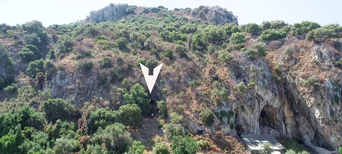 White arrow pointing to entrance of San Teodoro Cave, Sicily