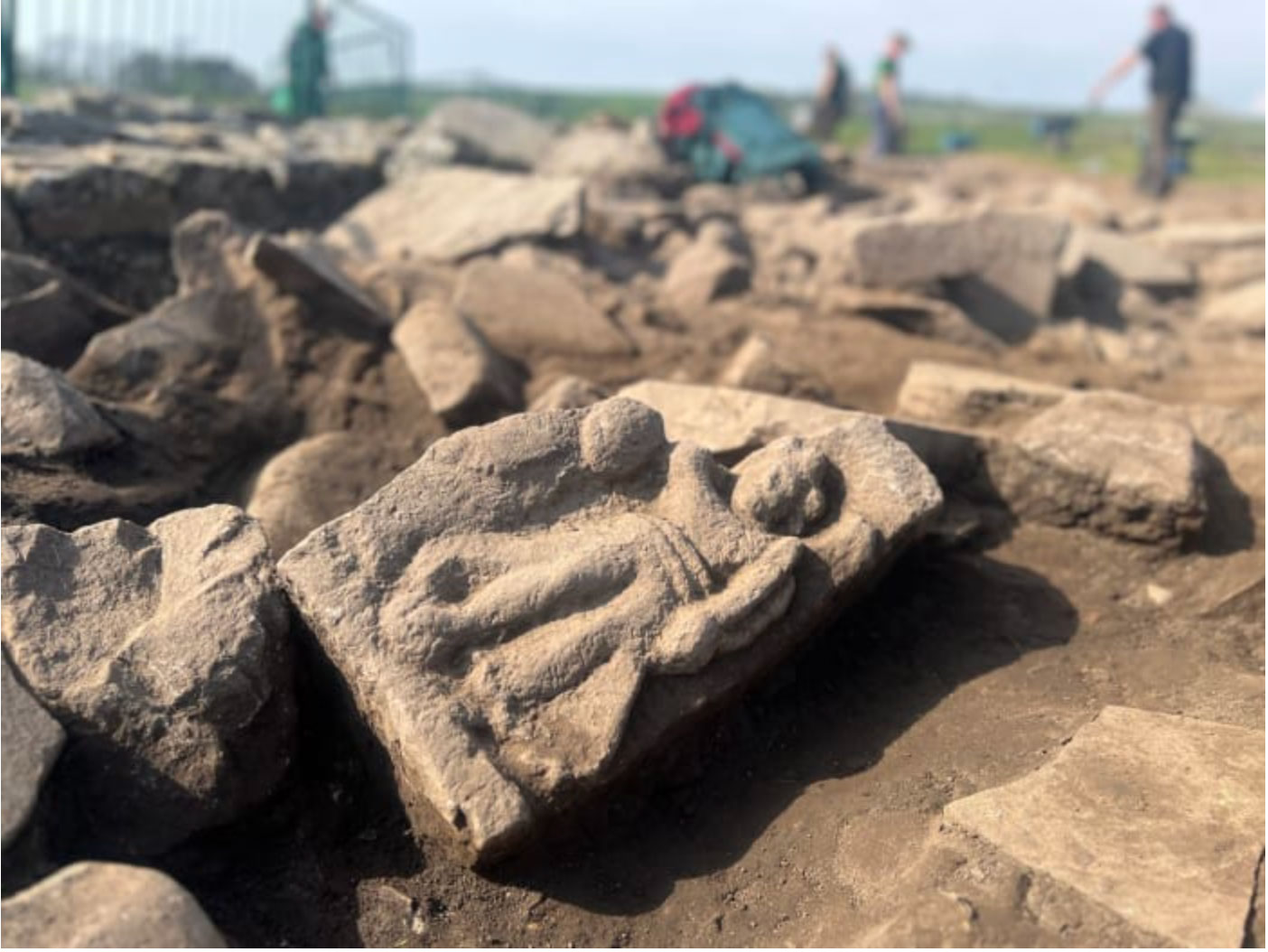Excavation of a carved sandstone relief that may depict the goddess Victory at Vindolanda, England