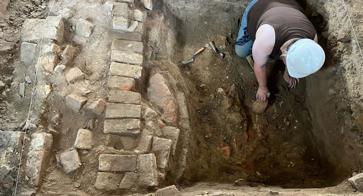 An archaeologist exposes a chimney base thought to be part of the original foundations of the Bray School in Williamsburg, Virginia