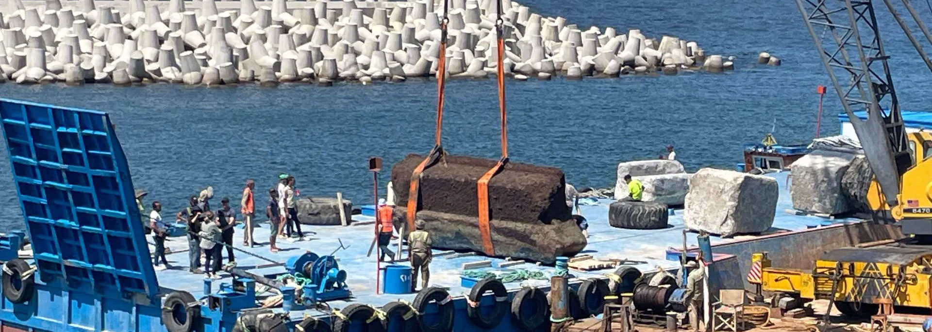 A crane lifts a block from the Alexandria Lighthouse onto a barge in Alexandria, Egypt