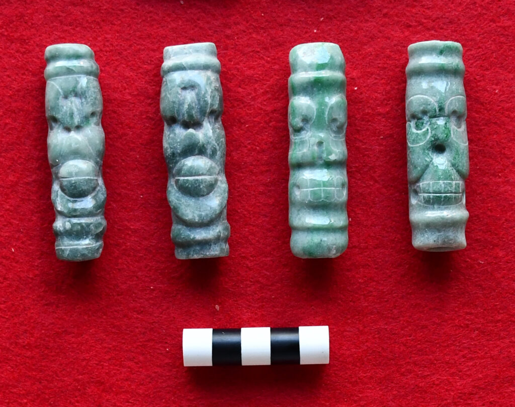 Jadeite tubular beads depicting live and dead spider monkeys