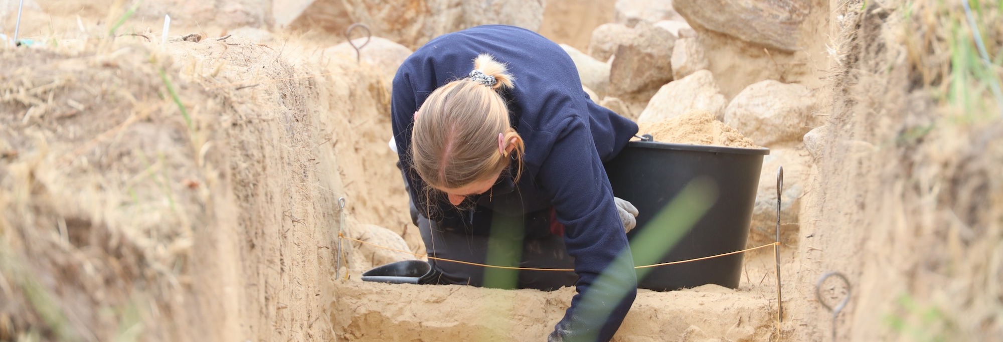 An archaeologist excavates a tomb enclosure in Chlapowski Landscape Park, Wyskoc, Poland