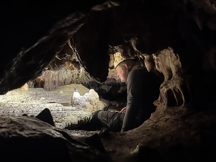 Researcher Daniel H. James installs a drip rate monitor on a flowstone in Grutas Tzabnah as part of the wider cave monitoring campaign.