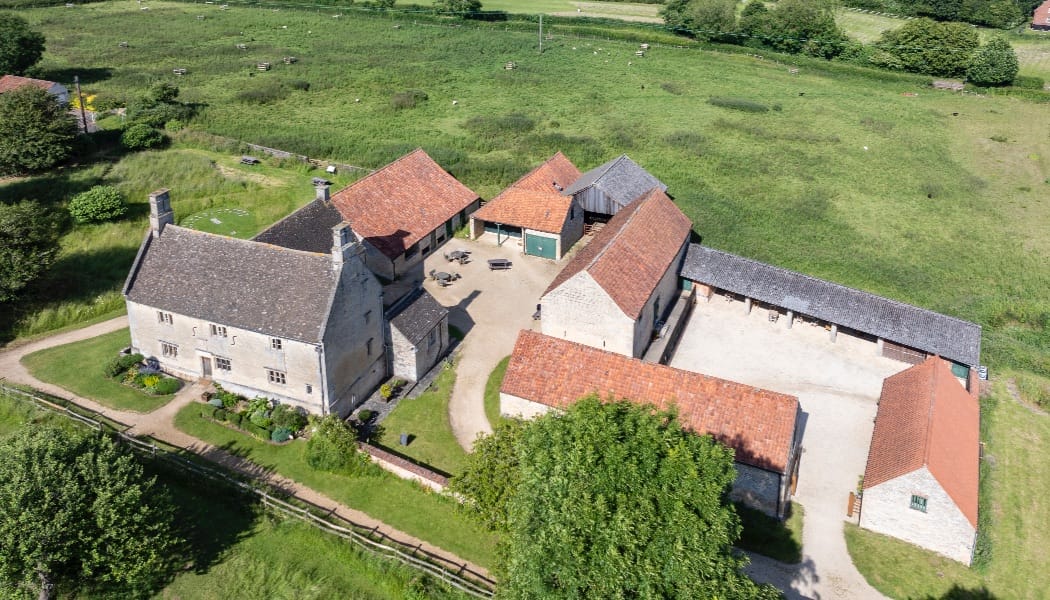 Woolsthorpe Manor with the field dug by archaeologists