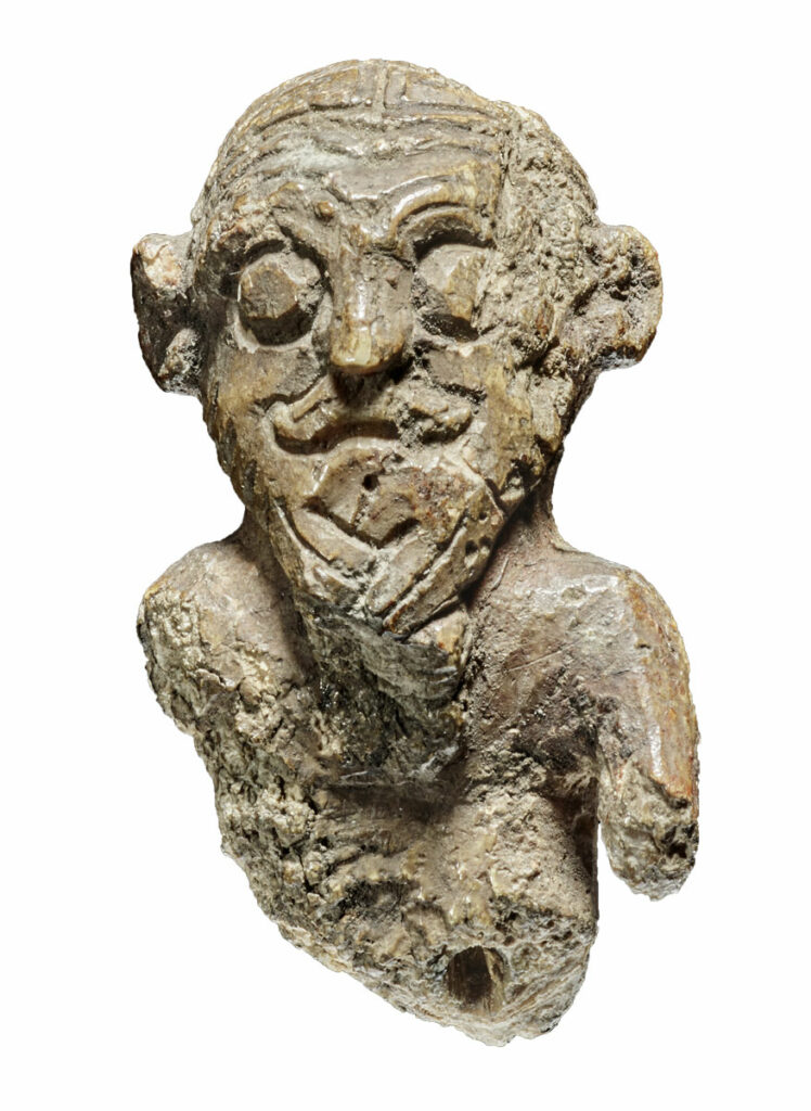 Front view of ivory gaming piece carved with a man's face