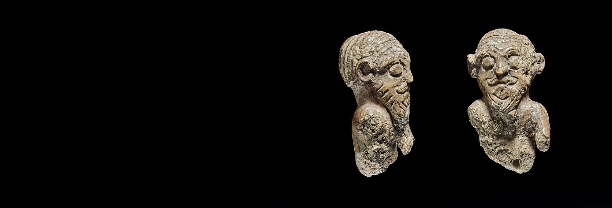 Side and front view of ivory gaming piece carved with a man's face