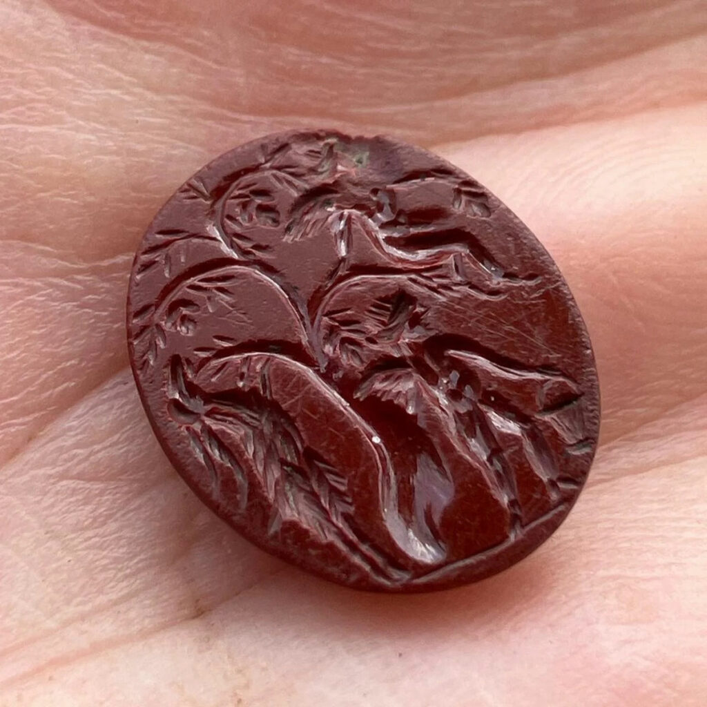 Intaglio depicting two cupids picking grapes from a tree with a goat-like creature beside them