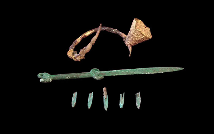 Top to bottom: Saka gold earring, sword, and metal arrowheads