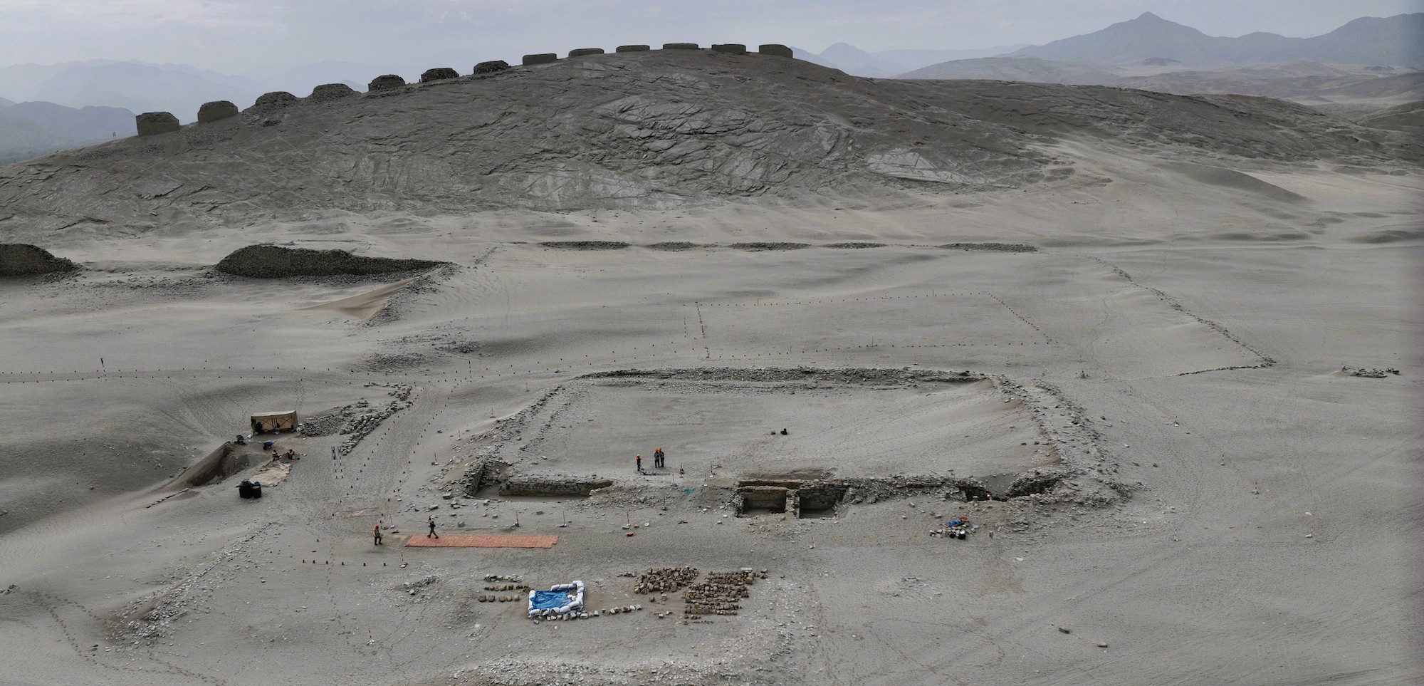 View of excavated structure (foreground) and Thirteen Towers (on hill in background) at Chankillo, Ancash, Peru