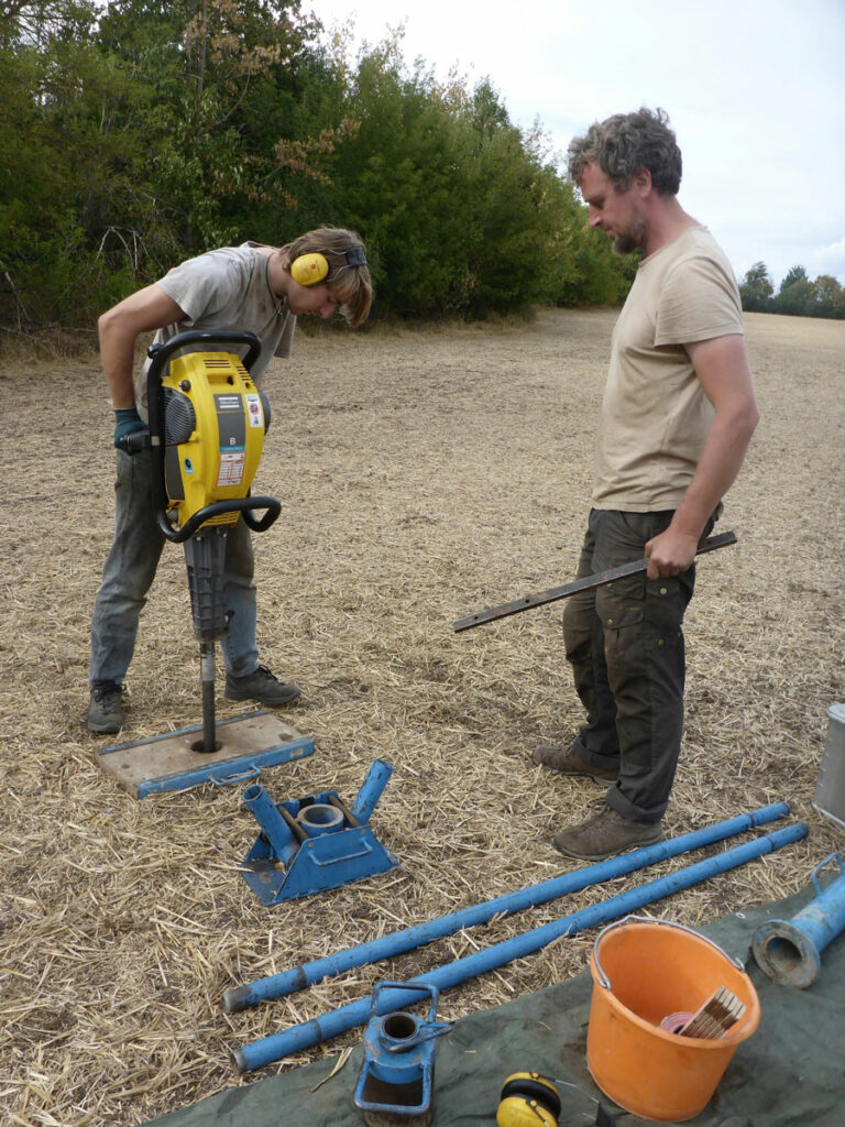 Nik Usmar (left) and Dr. Michael Hein (right) carry out sediment coring to locate a medieval plague mass grave near Erfurt, Germany.