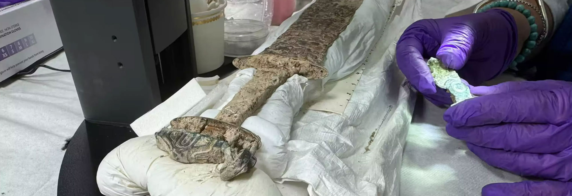 A researcher analyzes an Anglo-Saxon sword in the lab.