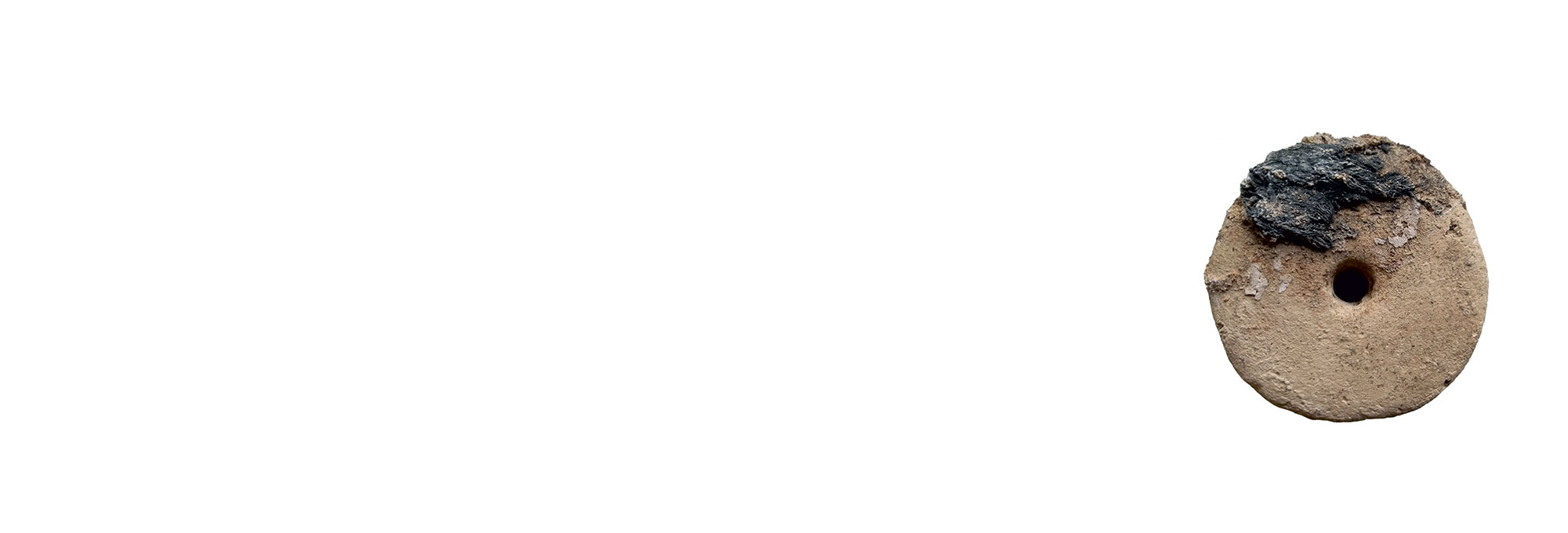 Loom weight encrusted with charred esparto grass