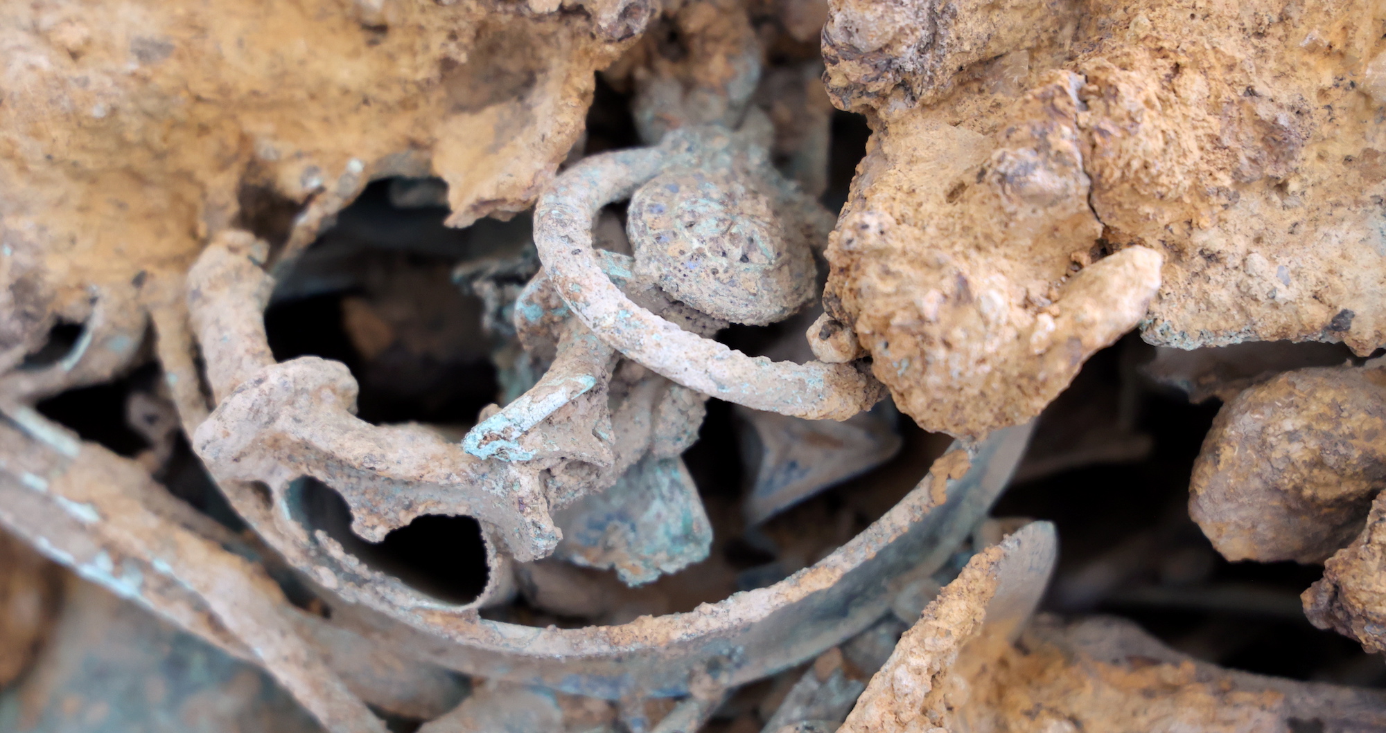 Tangled Iron Age metal artifacts stick out of the block that was excavated during the dig at Melsonby, England.