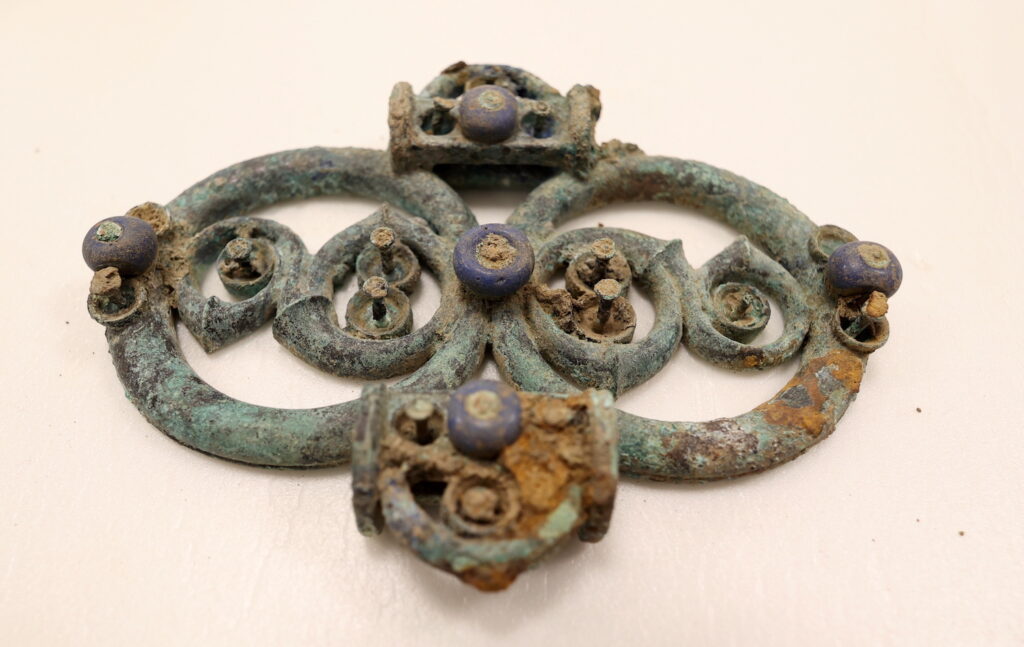 Copper alloy harness fitting with blue glass decoration