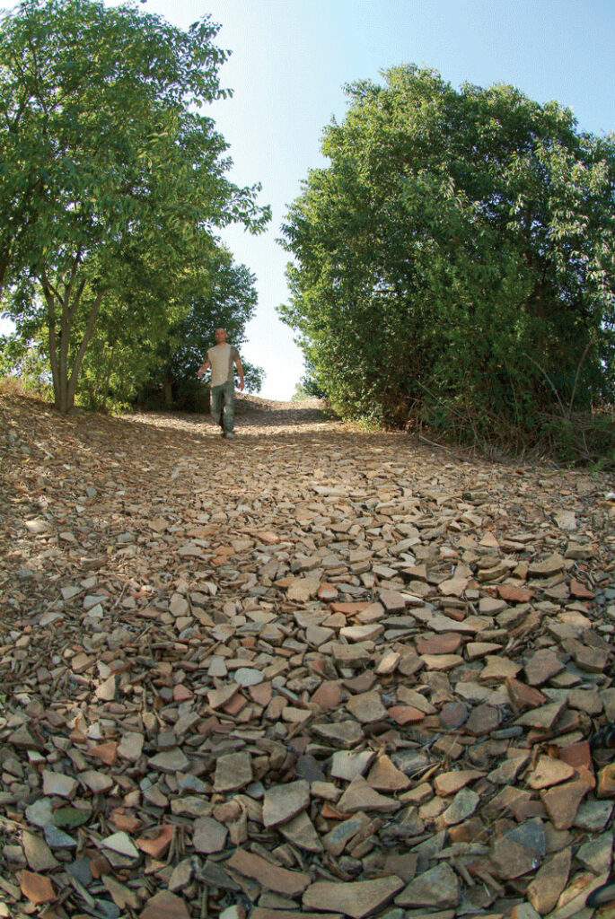An excavation worker walks down a sherd-strewn path from the top of Monte Testaccio.
