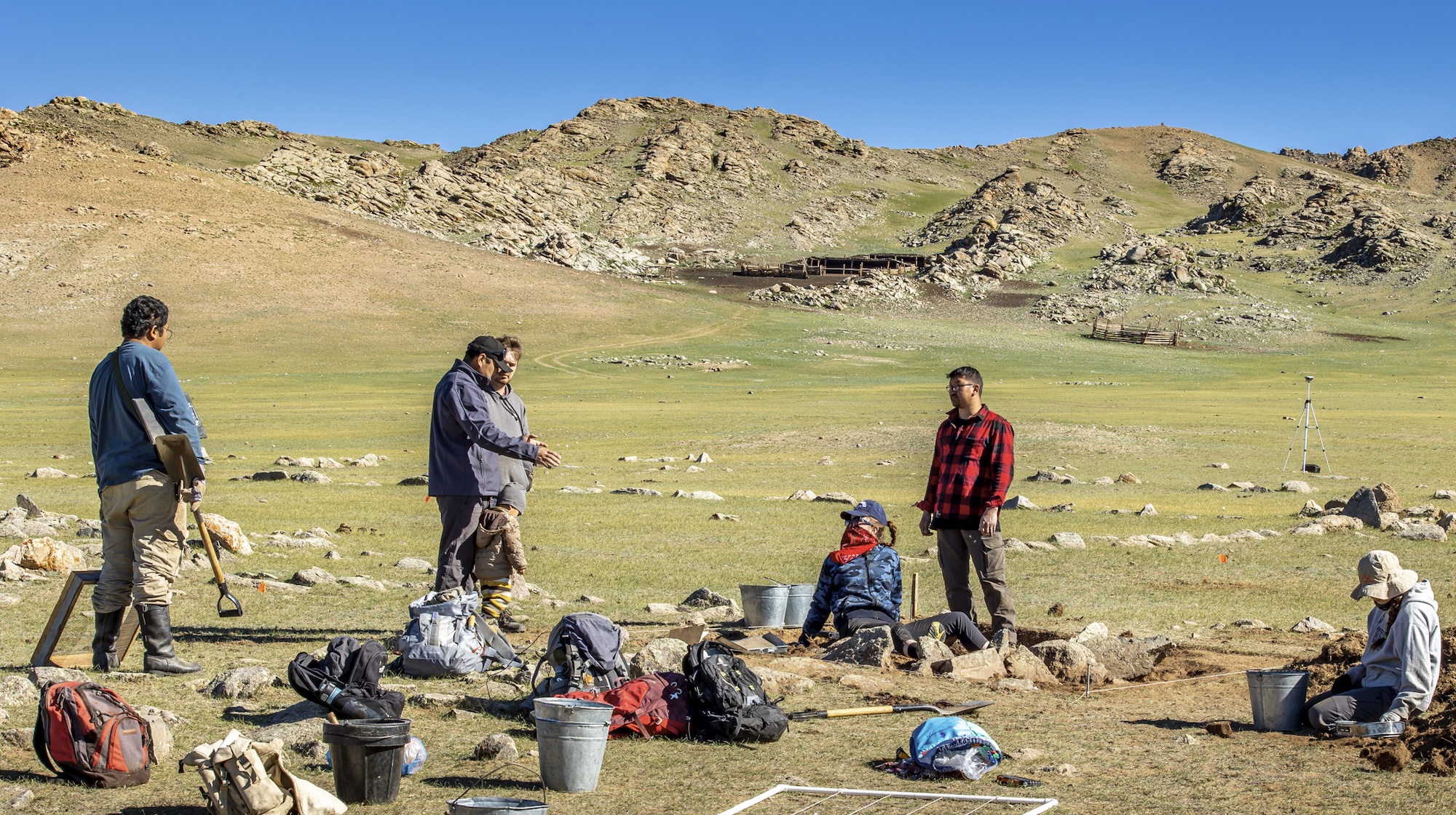 Archaeologists excavate a mound with a horse skull at khirigsuur ZK956, with ZK513 habitation site visible in the background