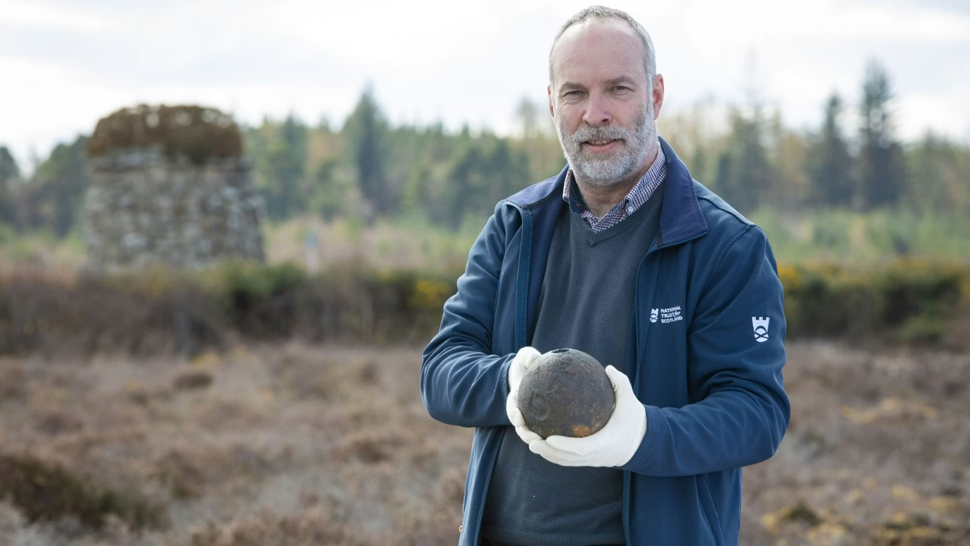 Derek Alexander holding mortar shell on Culloden Battlefield, Scotland