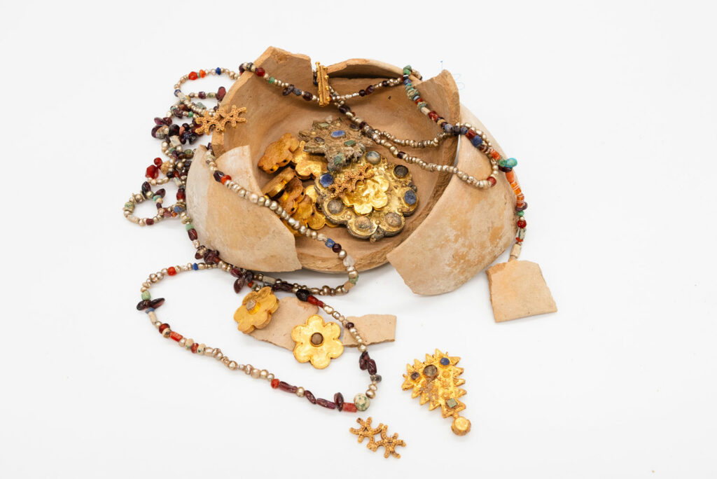 Ceramic jar with gold and silver jewelry
