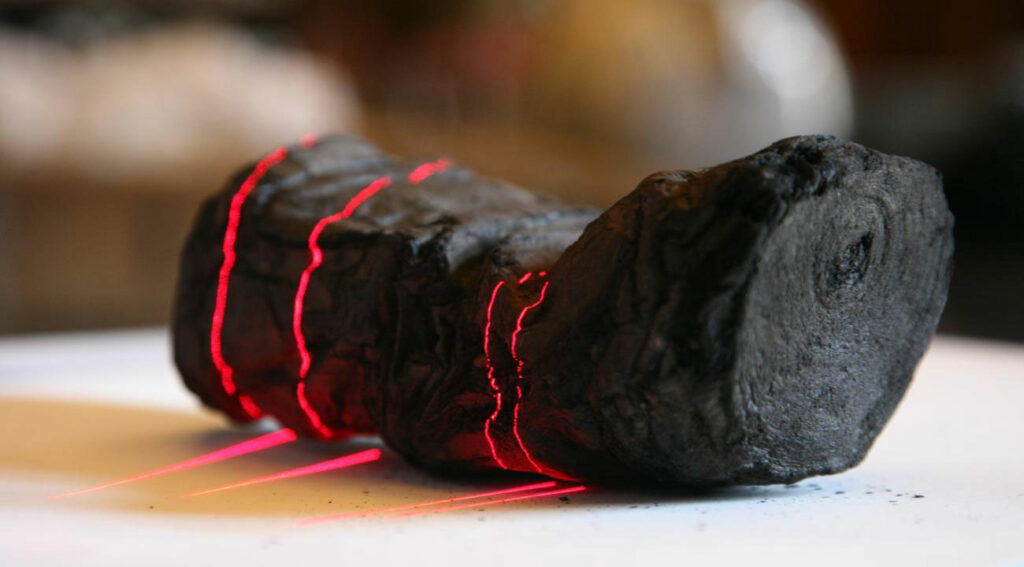 Herculaneum scroll with red laser lines being scanned at Institut de France by Brent Seales and his team