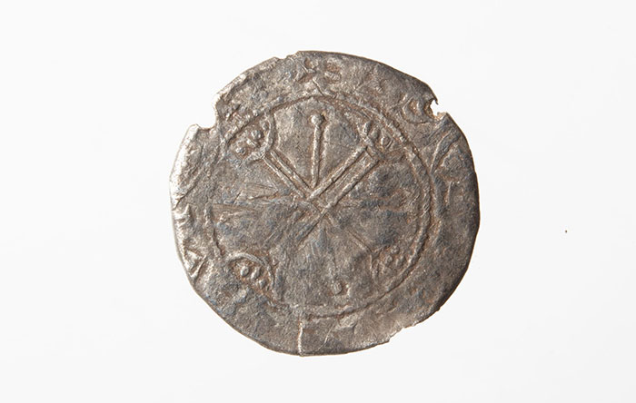 Front of coin featuring a cross over cross motif