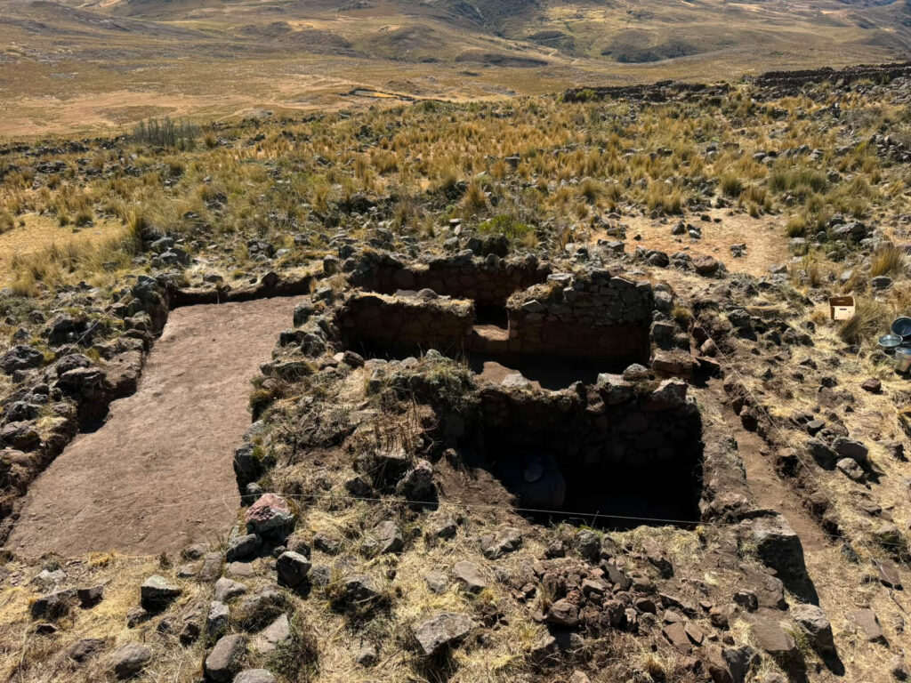 Excavated Huaylas house in Ancash, Peru, with view of surrounding landscape in the background