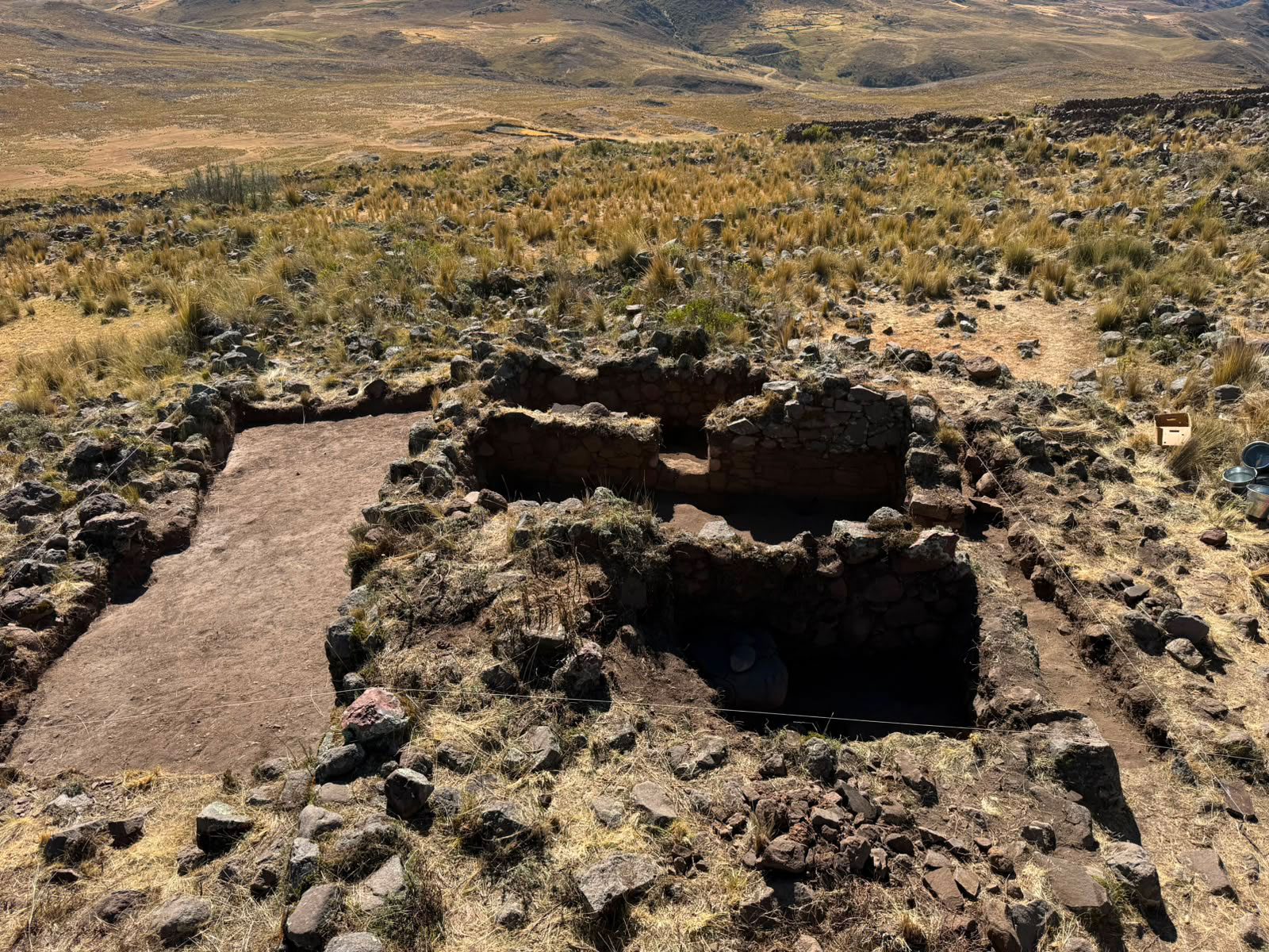 Excavated Huaylas house in Ancash, Peru, with view of surrounding landscape in the background