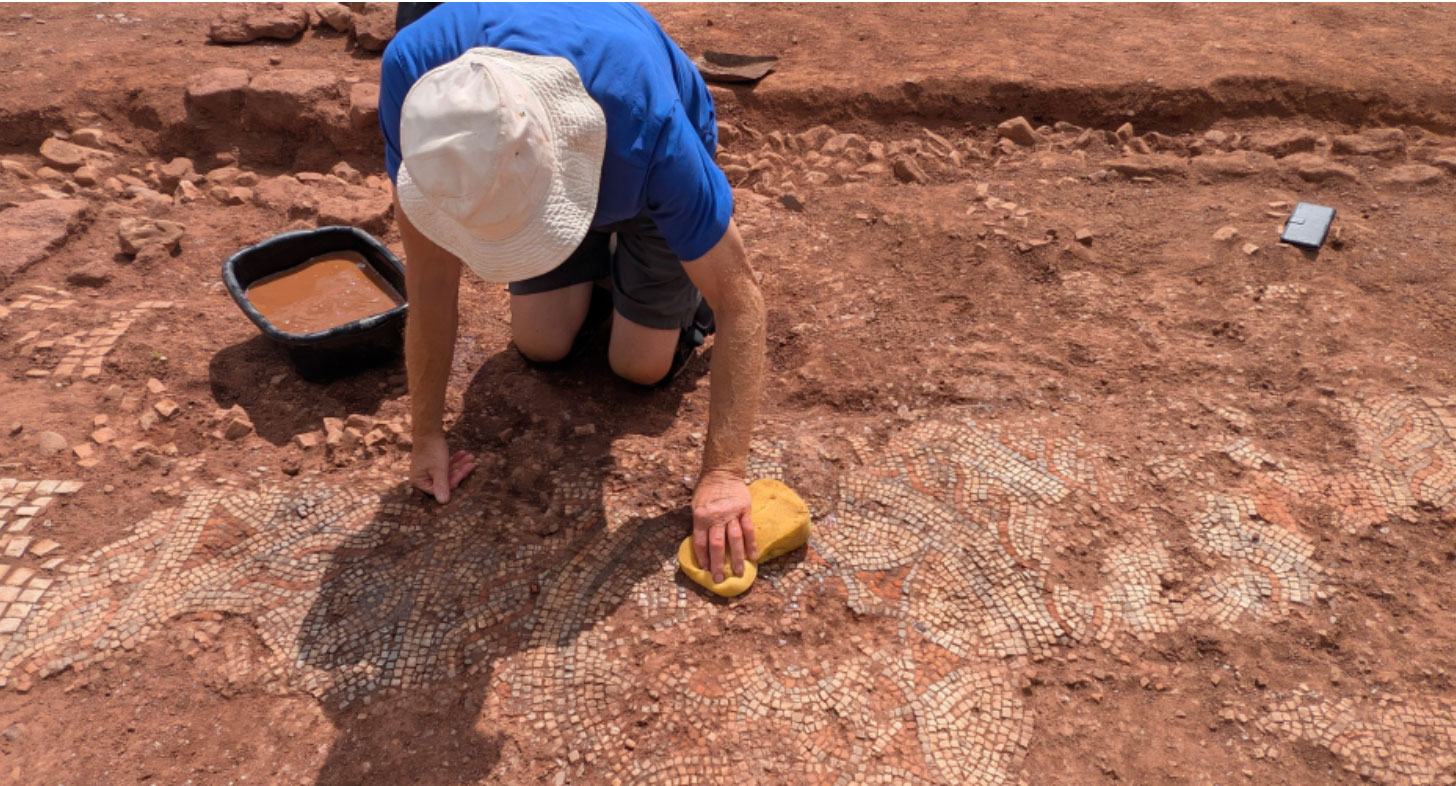 Archaeologist excavates mosaic floor, Devon, England