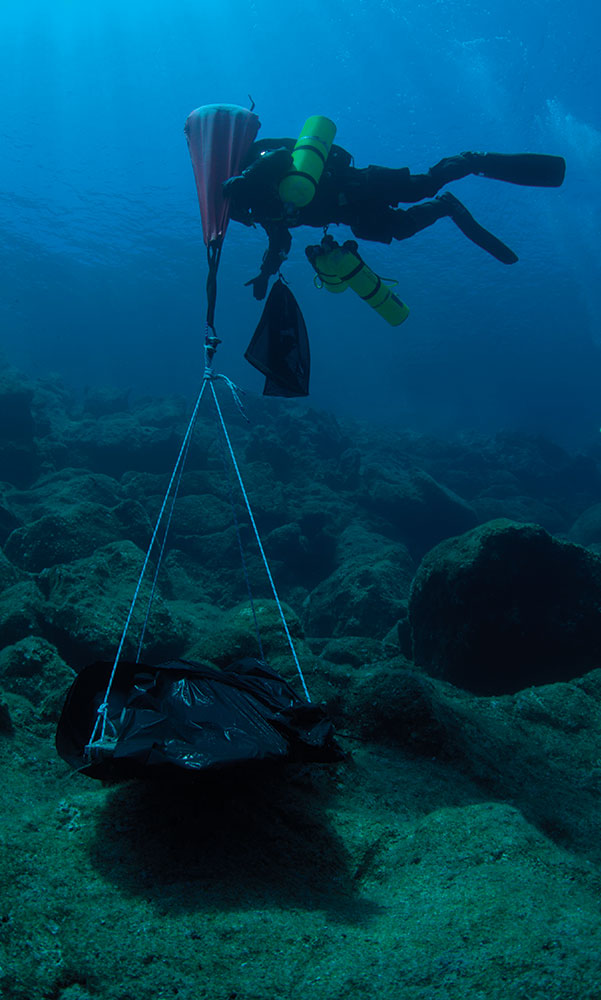 A diver lifts a section of hull from a ship that sank off the eastern coast of the Greek island of Antikythera