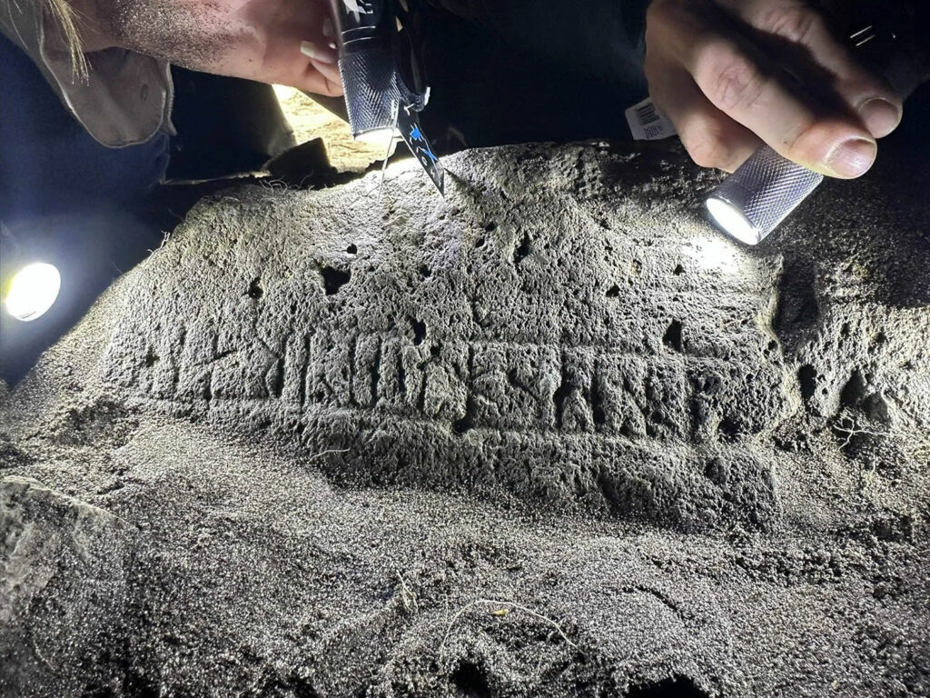 Carved runestone illuminated by flashlight
