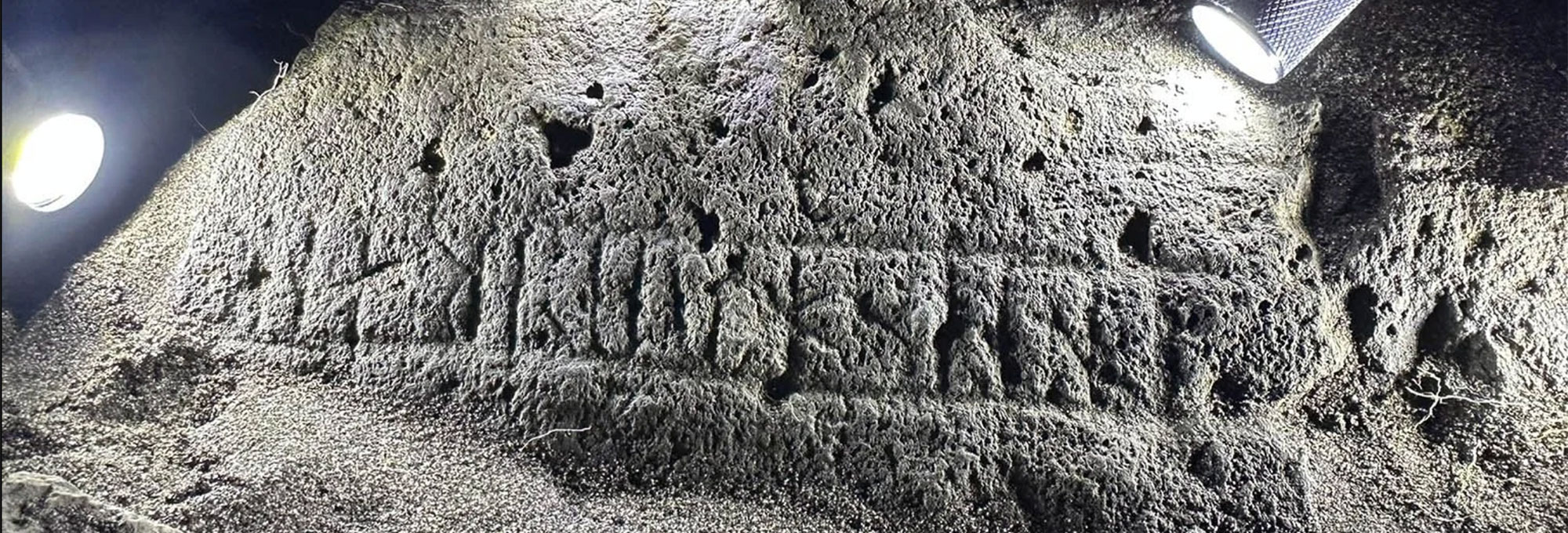 Carved runestone illuminated by flashlight